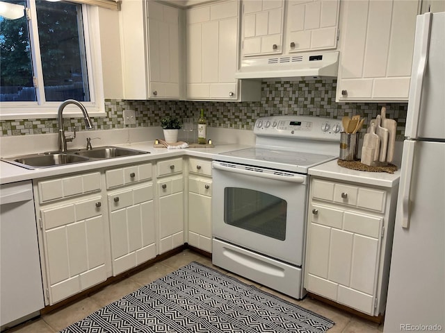 kitchen with light tile patterned flooring, white appliances, sink, and white cabinets