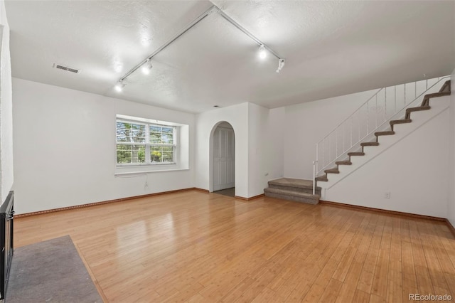 unfurnished living room with hardwood / wood-style flooring and a textured ceiling