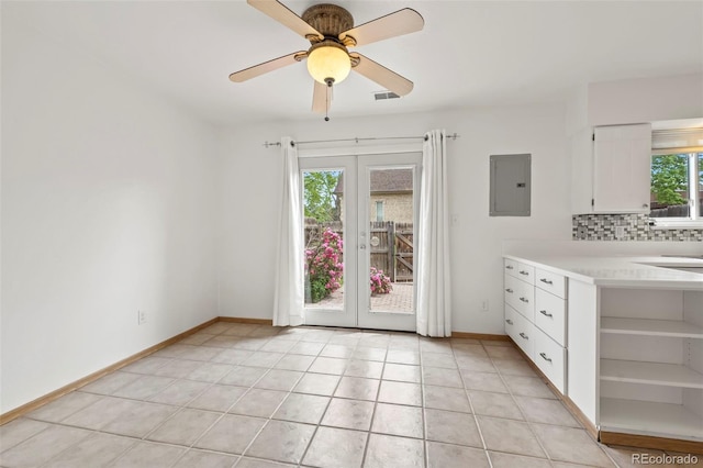 interior space with backsplash, electric panel, french doors, and white cabinets