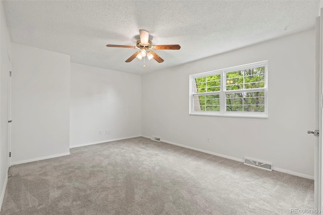 empty room with ceiling fan, carpet flooring, and a textured ceiling