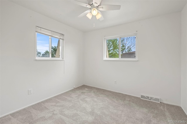 carpeted empty room featuring ceiling fan and a healthy amount of sunlight