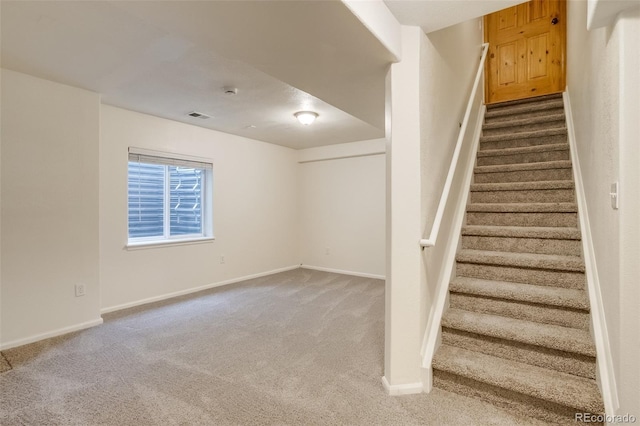 stairs with carpet floors, visible vents, and baseboards