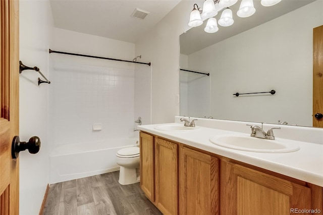 bathroom featuring toilet, double vanity, a sink, and visible vents