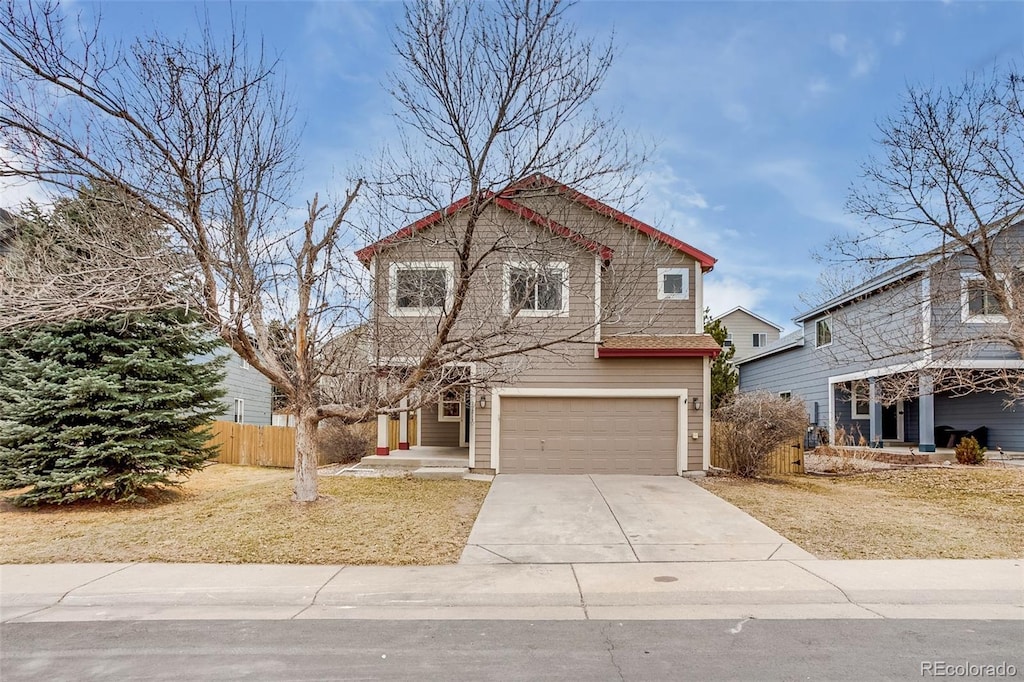 traditional-style house featuring a garage, fence, and driveway