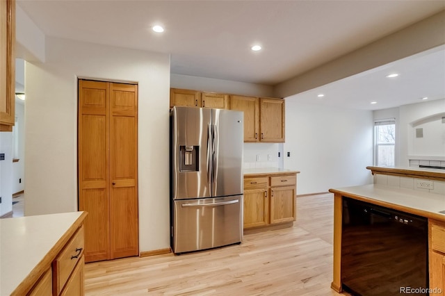 kitchen with black dishwasher, light wood-style flooring, light countertops, and stainless steel fridge with ice dispenser