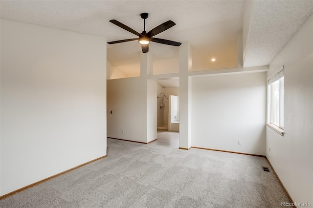 carpeted spare room with a ceiling fan, visible vents, a textured ceiling, and baseboards