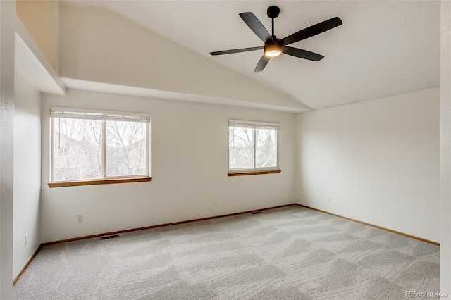 unfurnished room featuring lofted ceiling, light carpet, a ceiling fan, visible vents, and baseboards