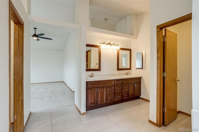 full bathroom featuring ceiling fan, lofted ceiling, a sink, and double vanity