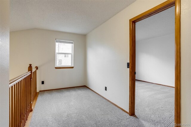 bonus room with a textured ceiling, vaulted ceiling, carpet, and baseboards