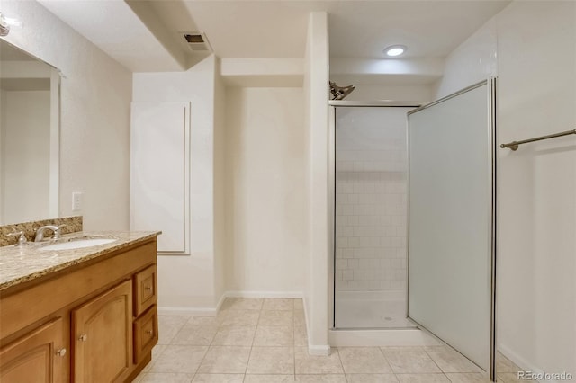 full bath with a stall shower, tile patterned flooring, vanity, and baseboards