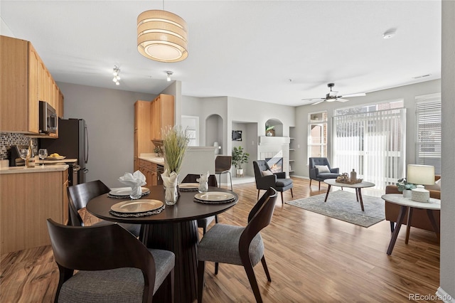 dining area with ceiling fan and light hardwood / wood-style flooring