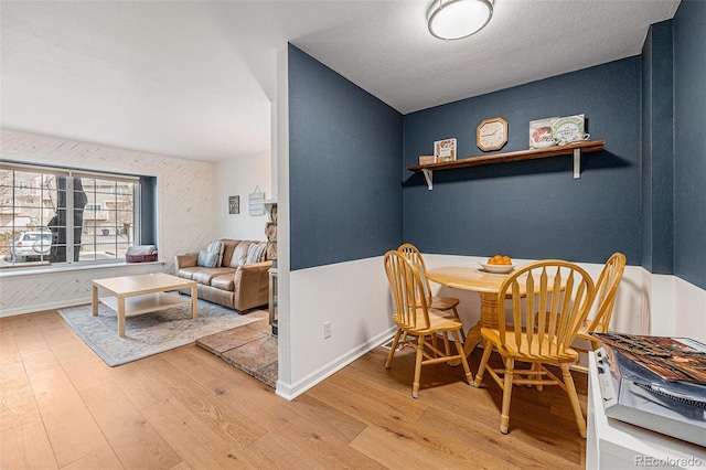 dining space with light wood-type flooring and baseboards