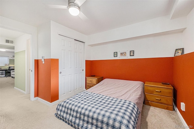 carpeted bedroom featuring a ceiling fan, visible vents, a closet, and baseboards
