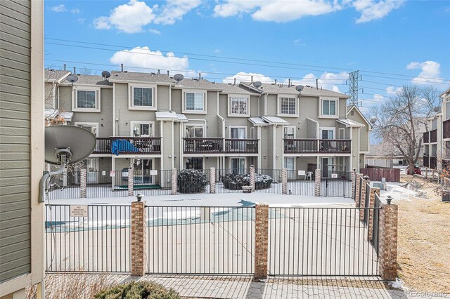 exterior space with a residential view, a community pool, and fence