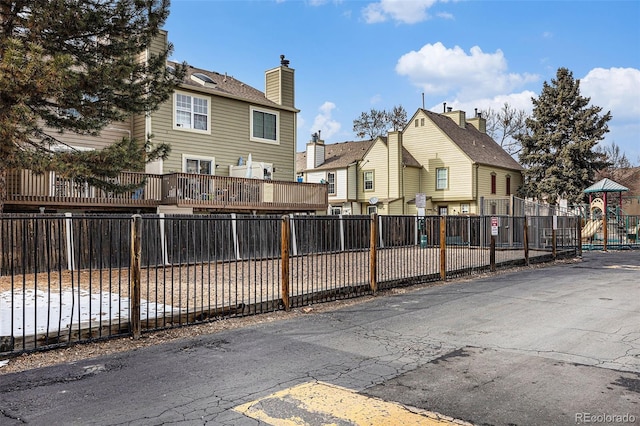 exterior space featuring a residential view, a playground, and fence