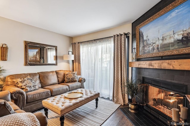 living room featuring a tiled fireplace and hardwood / wood-style floors