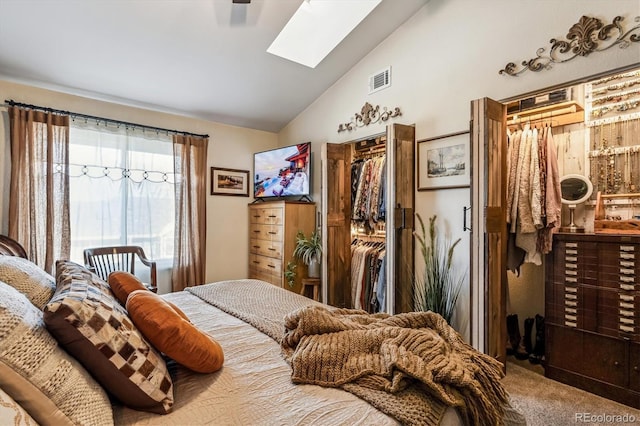 carpeted bedroom featuring lofted ceiling with skylight and a closet