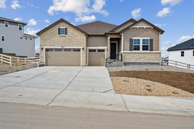 4975 Hickory Oaks St, Castle Rock, CO 80104 - craftsman-style house with driveway, stone siding, fence, board and batten siding, and a garage
