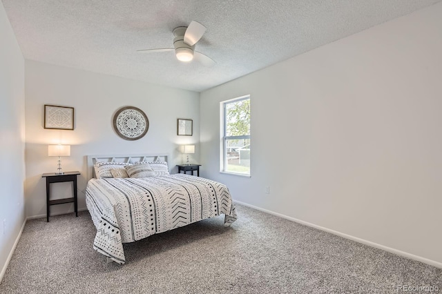 carpeted bedroom featuring baseboards, a ceiling fan, and a textured ceiling