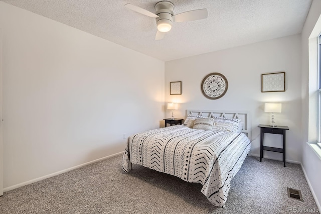 carpeted bedroom featuring a textured ceiling, a ceiling fan, and baseboards
