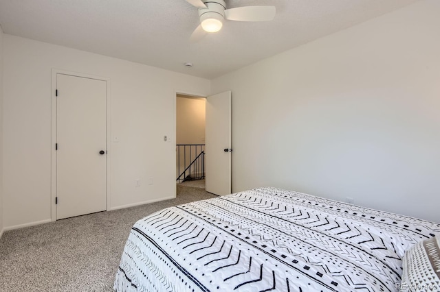 carpeted bedroom with ceiling fan and baseboards