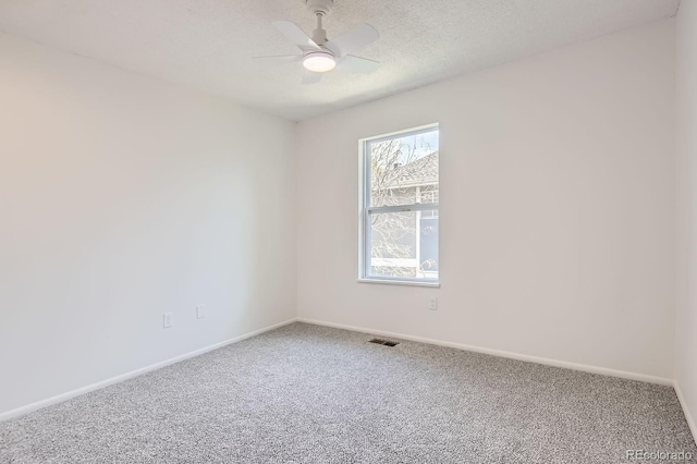 carpeted empty room featuring baseboards, a ceiling fan, and a textured ceiling