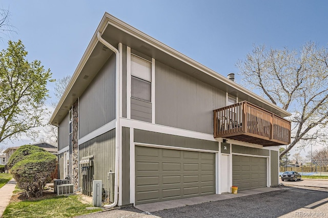 view of property exterior featuring a balcony and an attached garage