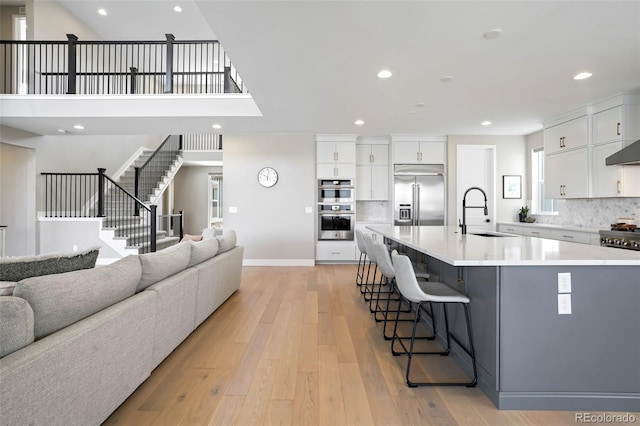 kitchen with white cabinets, appliances with stainless steel finishes, a spacious island, and sink