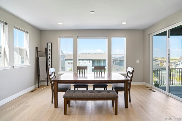 dining room with plenty of natural light and light hardwood / wood-style flooring