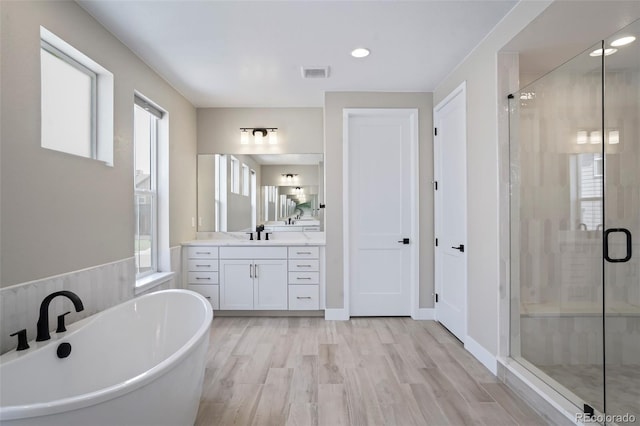 bathroom with vanity, wood-type flooring, and shower with separate bathtub