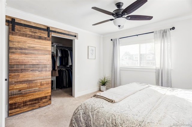 bedroom with crown molding, ceiling fan, a barn door, light colored carpet, and a closet