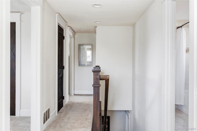 hall with light colored carpet