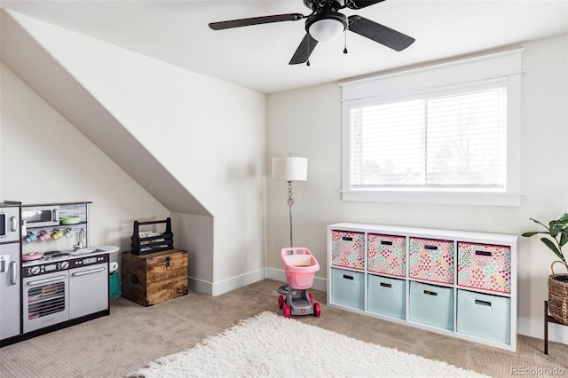 recreation room featuring ceiling fan, light carpet, and vaulted ceiling