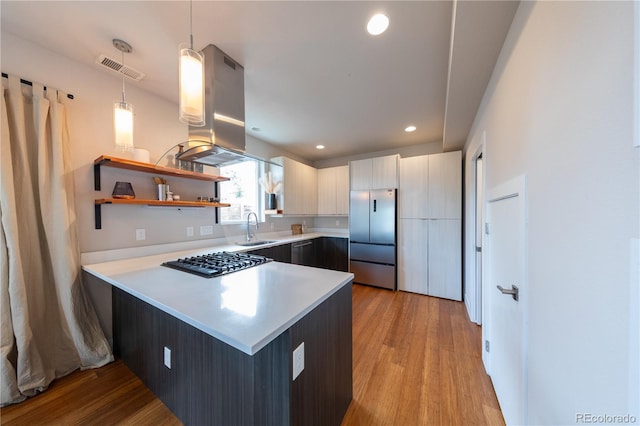 1355 Zenobia St, Denver, CO 80204 - kitchen with stainless steel built in refrigerator, island range hood, a sink, a peninsula, and light countertops