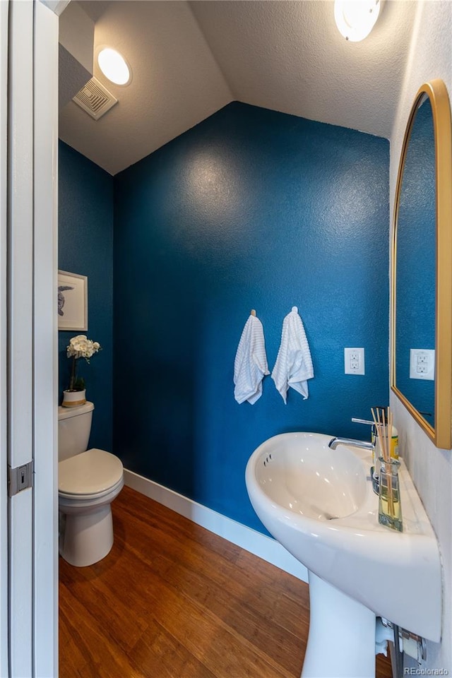 1355 Zenobia St, Denver, CO 80204 - half bath featuring wood finished floors, lofted ceiling, toilet, and baseboards