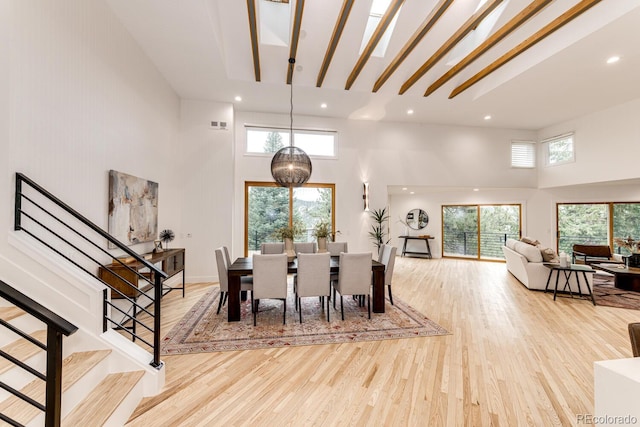 dining room featuring light hardwood / wood-style floors, a high ceiling, and a wealth of natural light