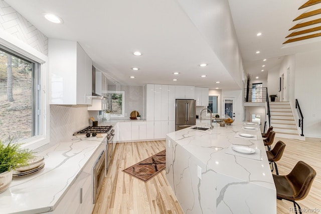 kitchen with appliances with stainless steel finishes, a breakfast bar area, white cabinets, and a spacious island