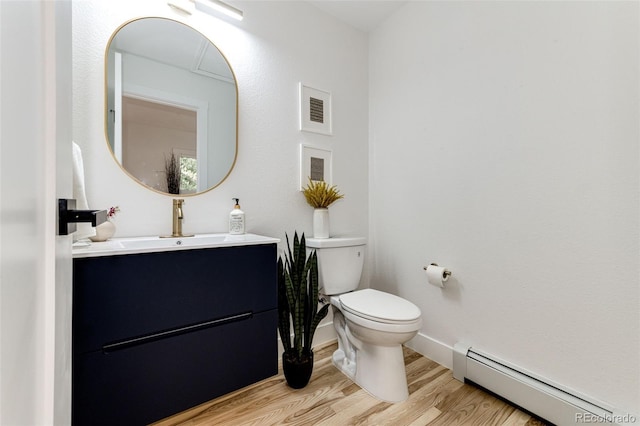 bathroom with hardwood / wood-style flooring, a baseboard radiator, vanity, and toilet