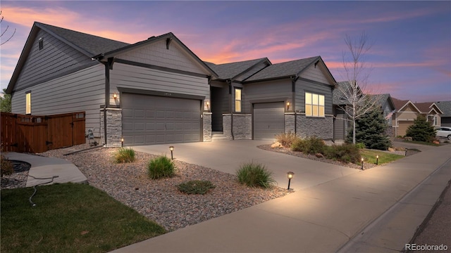 view of front of house with driveway, a shingled roof, an attached garage, and fence