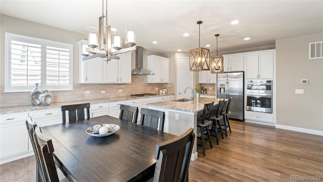dining space with visible vents, recessed lighting, an inviting chandelier, baseboards, and light wood-style floors
