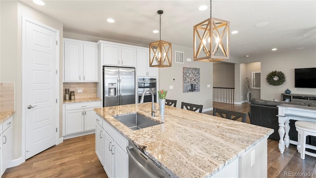 kitchen with a sink, stainless steel appliances, visible vents, recessed lighting, and open floor plan