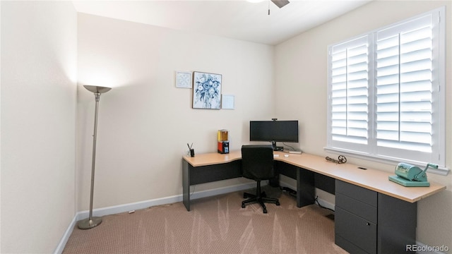 home office with baseboards, a ceiling fan, and light colored carpet
