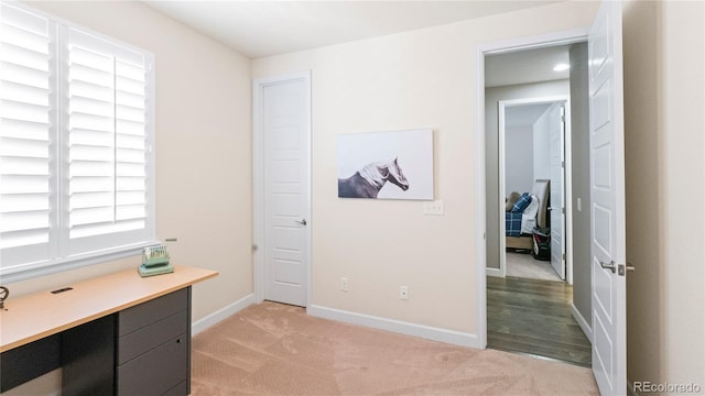 home office featuring light colored carpet and baseboards