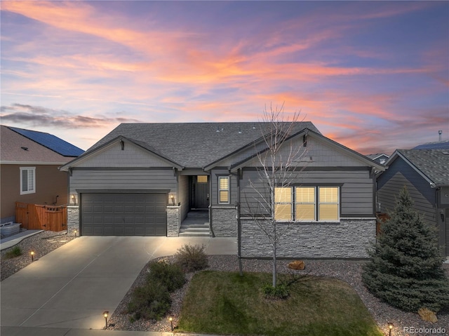 ranch-style house with stone siding, driveway, an attached garage, and fence