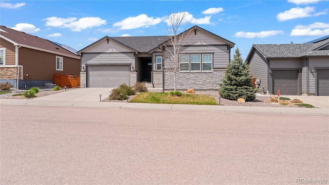 ranch-style house with a garage, stone siding, and driveway