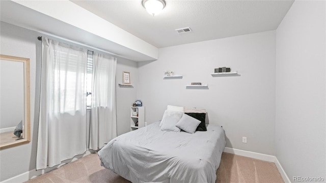 carpeted bedroom featuring baseboards and visible vents