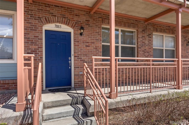 7883 W 55th Ave, Arvada, CO 80002 - entrance to property featuring brick siding and a porch