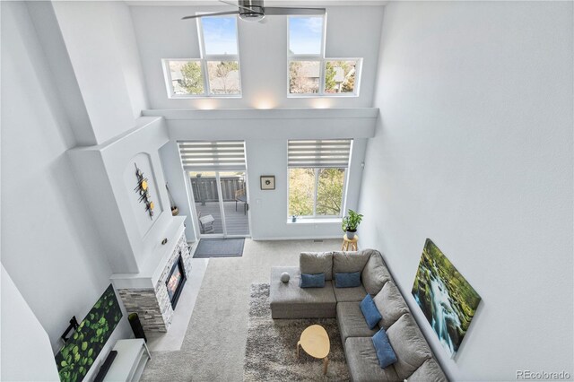 3425 W 111th Loop Unit B, Westminster, CO 80031 - living room with a towering ceiling, carpet flooring, a ceiling fan, and a fireplace with flush hearth