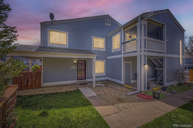 view of front of home featuring stairway, a front lawn, and fence
