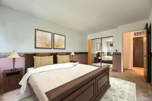 bedroom featuring a closet, visible vents, and light colored carpet